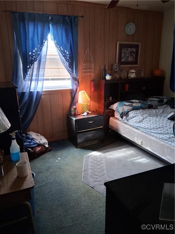 carpeted bedroom with wooden walls