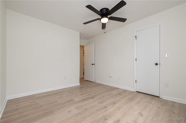 spare room featuring ceiling fan, baseboards, and light wood-style flooring