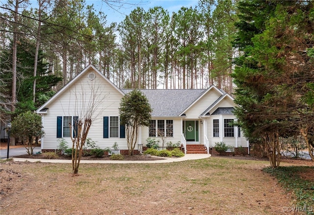 ranch-style home featuring crawl space, entry steps, a shingled roof, and a front lawn