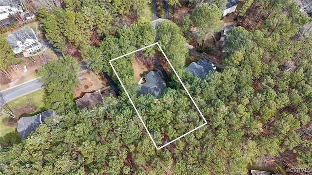 birds eye view of property featuring a forest view