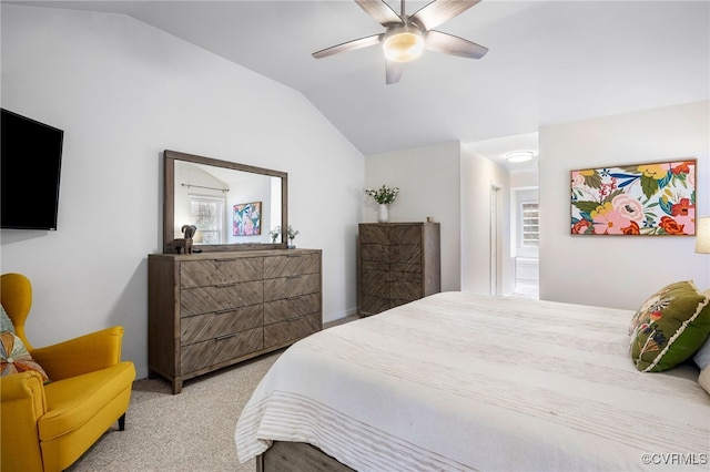 bedroom featuring connected bathroom, lofted ceiling, carpet floors, and a ceiling fan