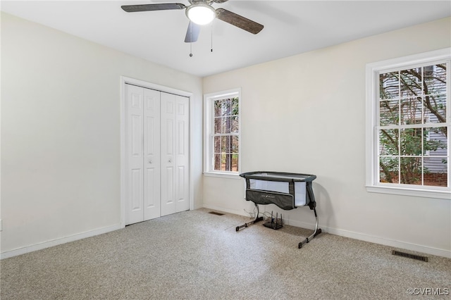 interior space with visible vents, carpet floors, baseboards, and ceiling fan