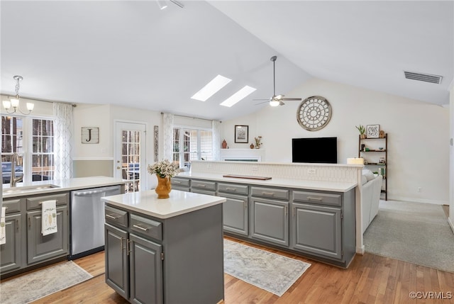 kitchen with visible vents, gray cabinets, a sink, a kitchen island, and dishwasher