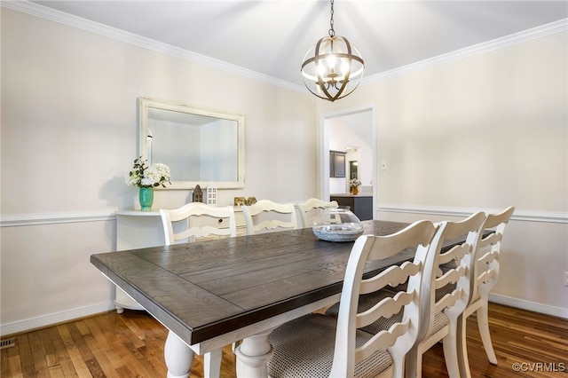 dining room with a chandelier, crown molding, baseboards, and wood-type flooring