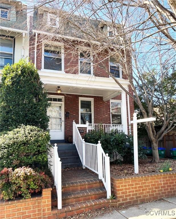 multi unit property featuring brick siding and covered porch