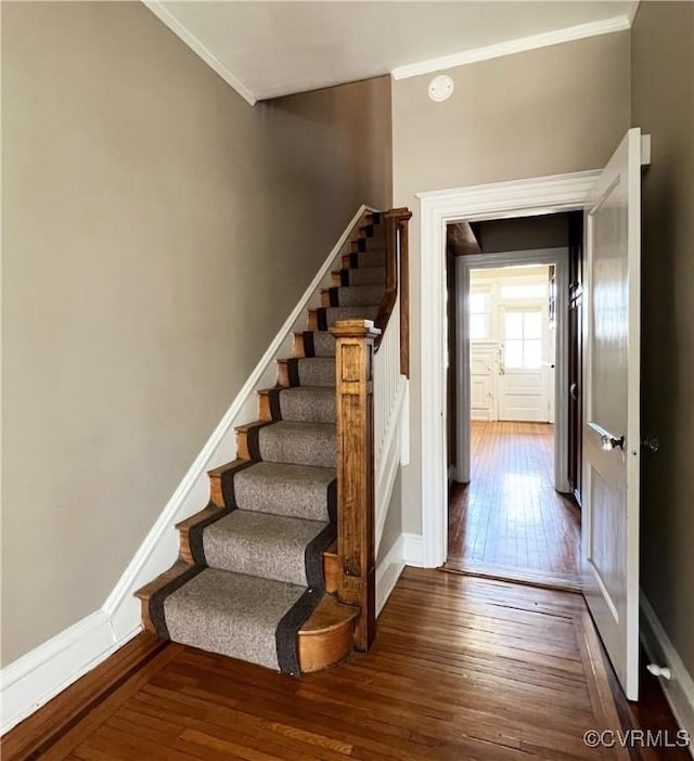 stairs with crown molding, baseboards, and hardwood / wood-style flooring