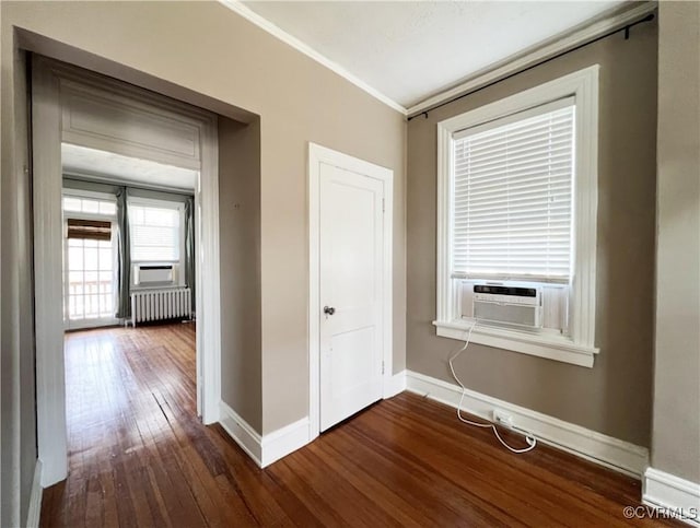 spare room featuring radiator, crown molding, baseboards, cooling unit, and dark wood-style flooring