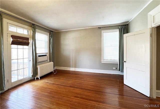 unfurnished room with hardwood / wood-style flooring, radiator, and a healthy amount of sunlight