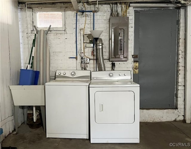 clothes washing area with washer and dryer, laundry area, and electric panel