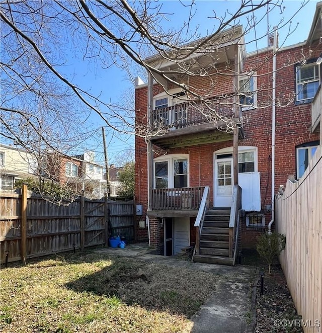 rear view of house featuring brick siding and a fenced backyard