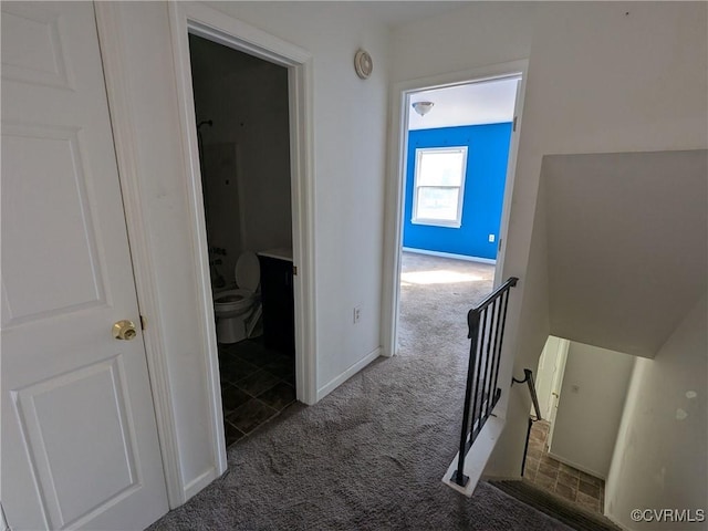 corridor featuring an upstairs landing, baseboards, and carpet floors