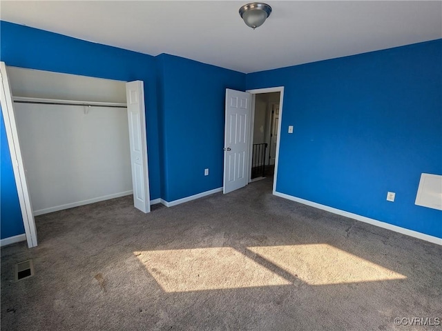 unfurnished bedroom with visible vents, baseboards, a closet, and carpet flooring