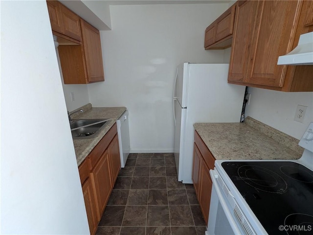 kitchen with under cabinet range hood, white appliances, brown cabinetry, and a sink