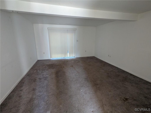 carpeted spare room with beam ceiling and baseboards