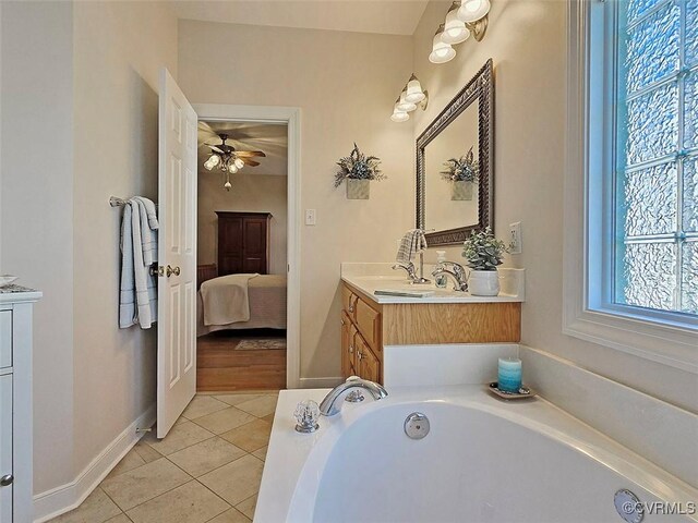 ensuite bathroom with baseboards, a bath, ensuite bathroom, tile patterned floors, and vanity