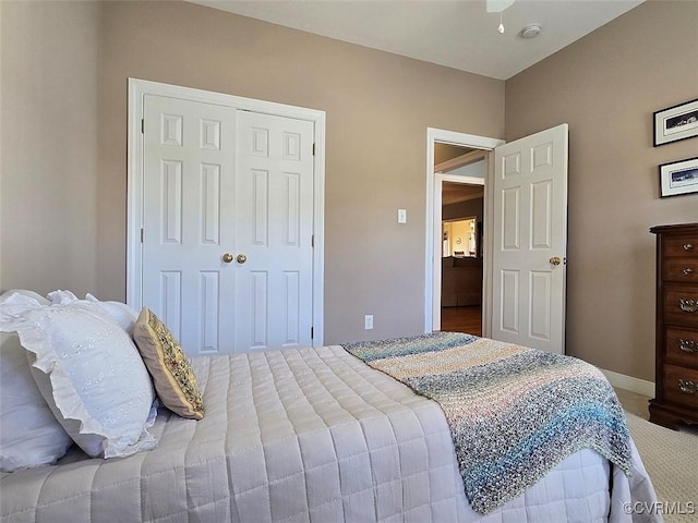 carpeted bedroom with a closet and baseboards