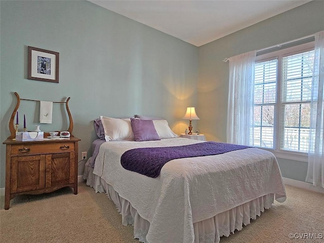 bedroom featuring light colored carpet and baseboards