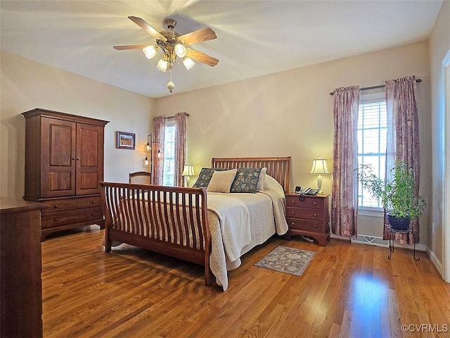 bedroom featuring a ceiling fan, wood finished floors, and baseboards