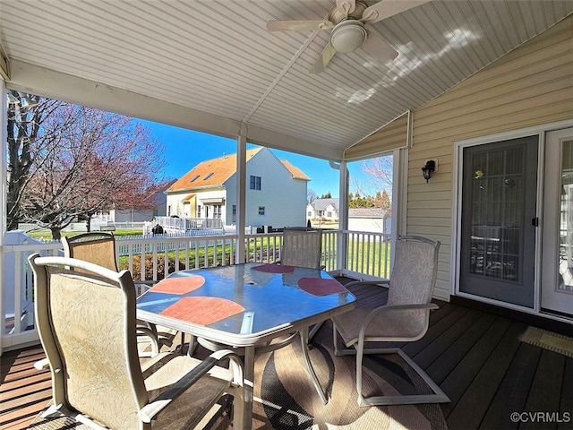 deck featuring a residential view, outdoor dining area, and a ceiling fan