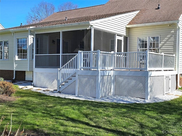 back of property featuring stairway, a lawn, roof with shingles, and a sunroom