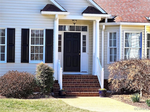 property entrance featuring roof with shingles