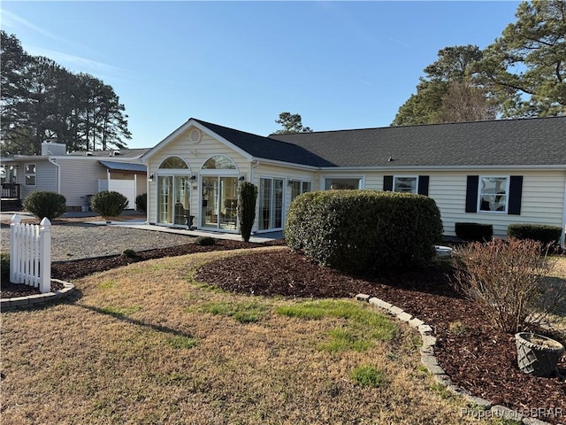 rear view of property featuring a lawn