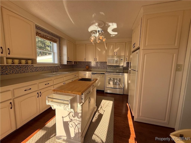 kitchen with a sink, backsplash, butcher block countertops, white appliances, and dark wood-style flooring