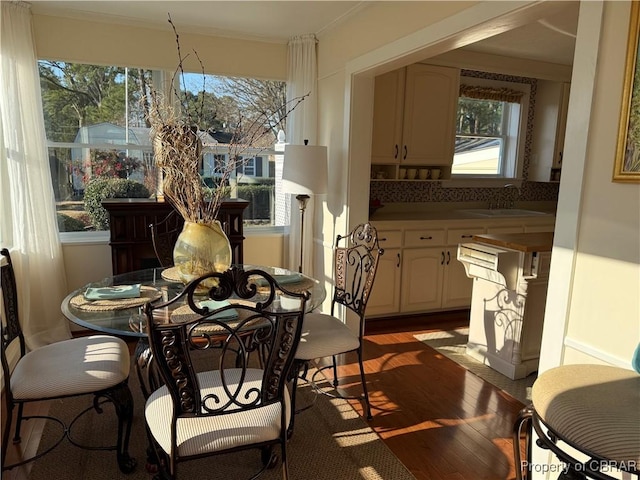 dining space featuring ornamental molding and wood finished floors