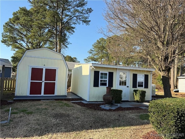 view of outdoor structure featuring an outbuilding and fence