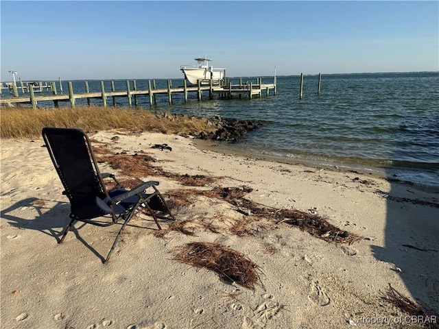 dock area featuring a water view and a beach view