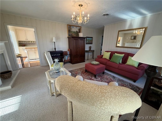 living area with visible vents, carpet floors, ornamental molding, a textured ceiling, and a notable chandelier