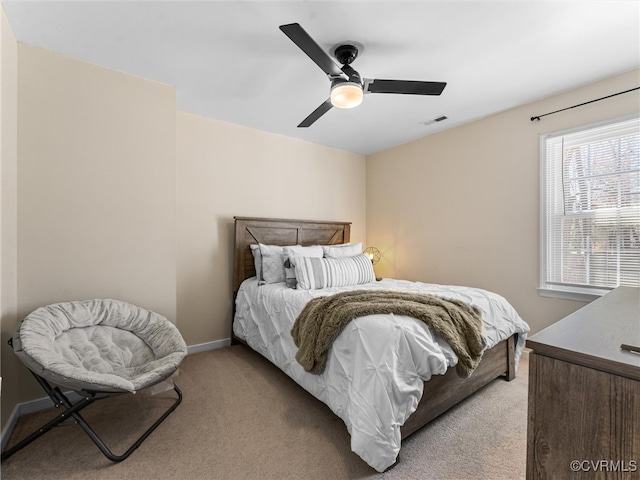 bedroom with visible vents, baseboards, light colored carpet, and ceiling fan