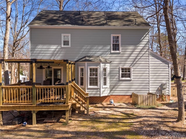 rear view of property with a deck and roof with shingles