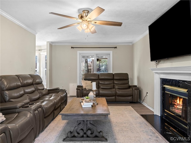 living room with crown molding, a wealth of natural light, and ceiling fan