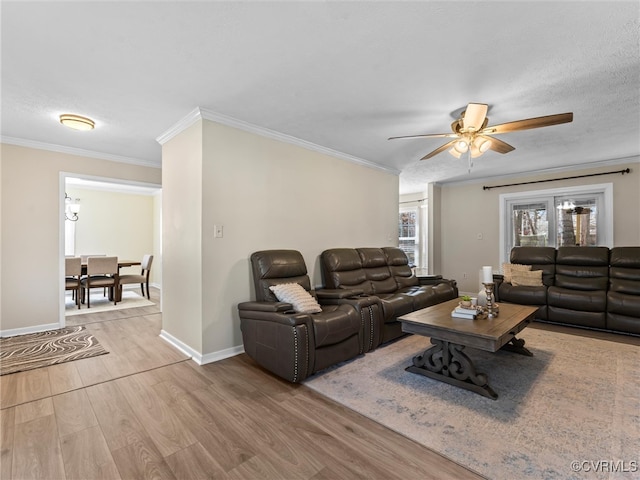 living room with ornamental molding, baseboards, ceiling fan, and wood finished floors