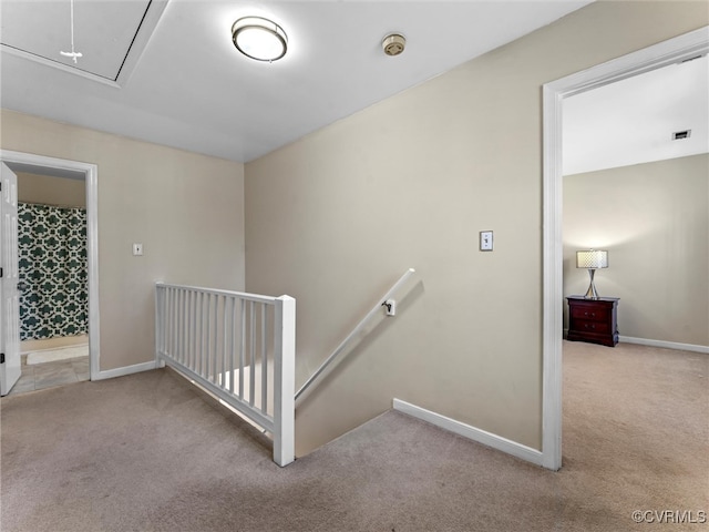 staircase with attic access, baseboards, visible vents, and carpet floors