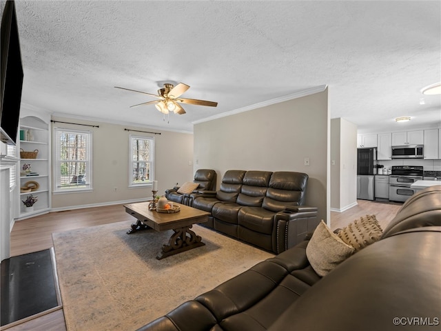 living area with ornamental molding, a ceiling fan, a textured ceiling, light wood-style floors, and baseboards