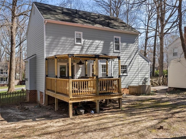 back of property with a wooden deck and fence