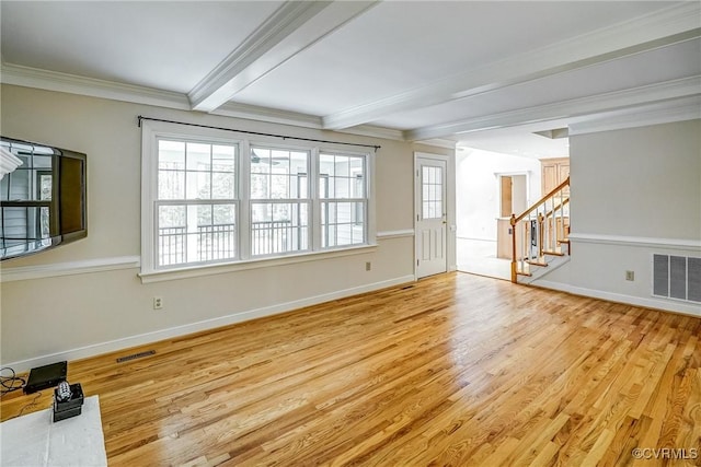 unfurnished living room featuring beam ceiling, wood finished floors, visible vents, and a wealth of natural light