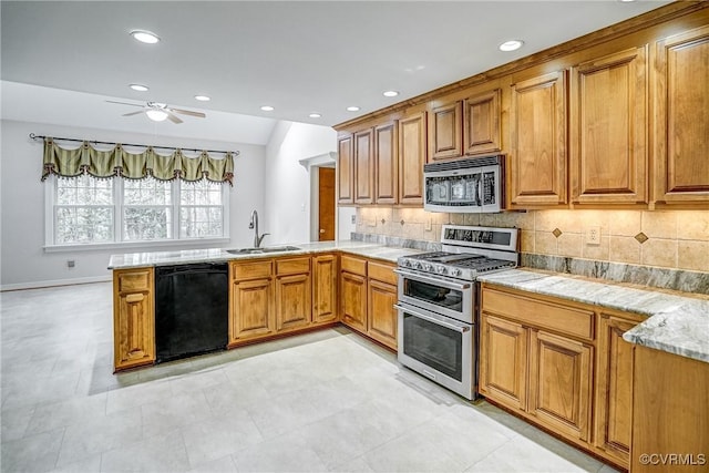 kitchen with a peninsula, brown cabinets, appliances with stainless steel finishes, and a sink