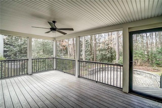 unfurnished sunroom featuring a ceiling fan