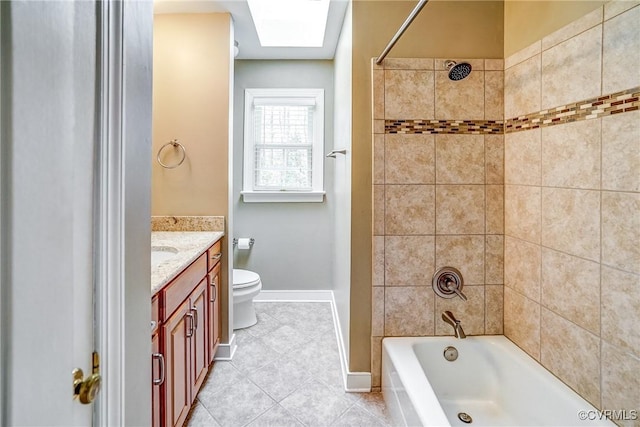 bathroom with toilet, a skylight, tile patterned floors, vanity, and  shower combination