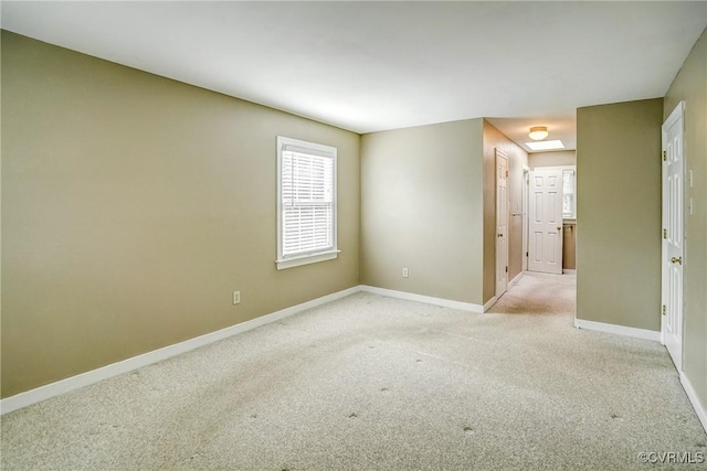 spare room with light colored carpet and baseboards