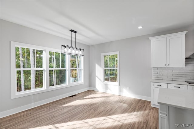 unfurnished dining area featuring recessed lighting, visible vents, baseboards, and light wood finished floors