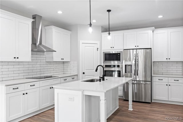 kitchen with light countertops, stainless steel appliances, white cabinetry, wall chimney exhaust hood, and a sink