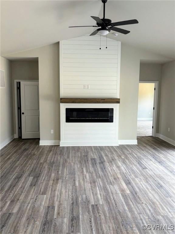 unfurnished living room featuring a large fireplace, lofted ceiling, and wood finished floors