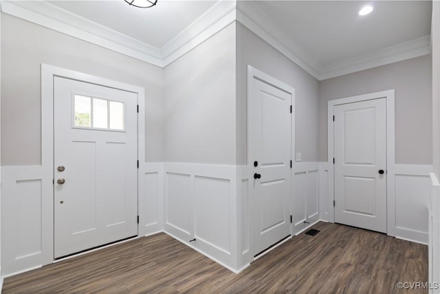 entryway with a wainscoted wall, crown molding, a decorative wall, and dark wood-type flooring