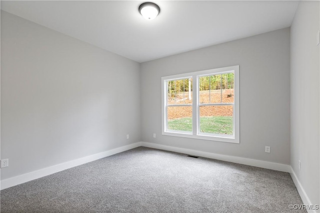 empty room with visible vents, baseboards, and carpet