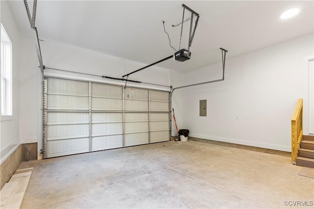 garage featuring electric panel, a garage door opener, and baseboards