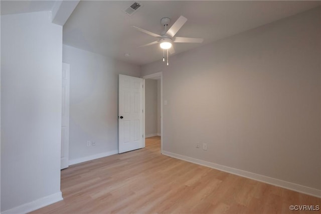 spare room featuring a ceiling fan, baseboards, visible vents, and light wood finished floors